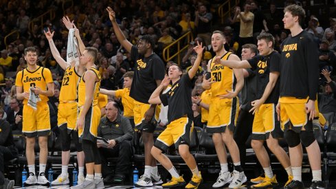 The Iowa bench stands and celebrates a three-pointer