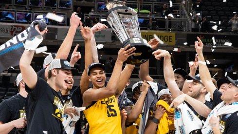 Keegan Murray holds up a trophy as his teammates celebrate