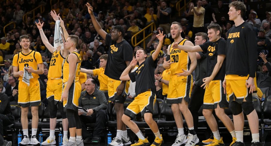 The Iowa bench stands and celebrates a three-pointer