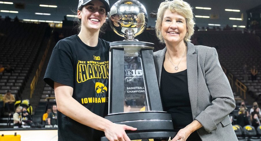 Caitlin Clark and Lisa Bluder hold the Big Ten Championship trophy