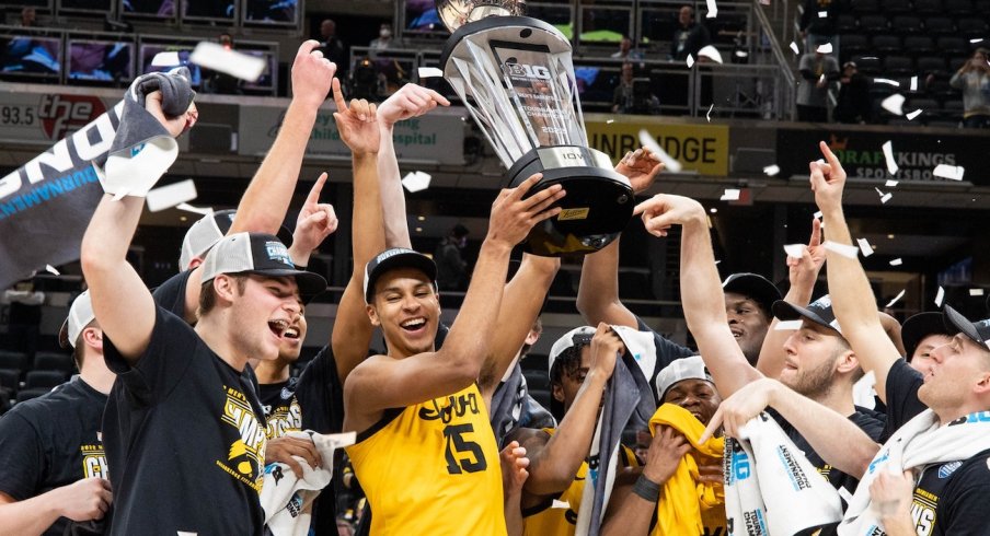 Keegan Murray holds up a trophy as his teammates celebrate